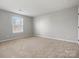 Neutral carpeted bedroom with window providing natural light at 9823 Shearwater Nw Ave, Concord, NC 28027