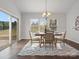 Bright dining room with a modern table, four chairs, and a large window at 9823 Shearwater Nw Ave, Concord, NC 28027