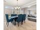 Elegant dining room featuring large windows, modern chandelier and seating for six guests at 9823 Shearwater Nw Ave, Concord, NC 28027