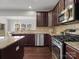 Modern kitchen with dark wood cabinets, stainless steel appliances, and granite countertops at 9823 Shearwater Nw Ave, Concord, NC 28027