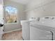 Well-equipped laundry room with washer, dryer, large arched window and shelving at 9823 Shearwater Nw Ave, Concord, NC 28027