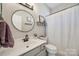 This bathroom features a large vanity, round mirror, and shower-tub combo with updated fixtures at 10390 Tintinhull Dr, Indian Land, SC 29707