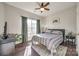 Cozy bedroom features natural light, wood floors, ceiling fan, and neutral decor at 10390 Tintinhull Dr, Indian Land, SC 29707