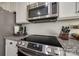 Close up of a kitchen with stainless steel microwave and oven with granite countertops at 10390 Tintinhull Dr, Indian Land, SC 29707