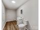 Simple bathroom featuring a white vanity, toilet, and wood look floors against pale colored walls at 107 Rutledge Rd, Mount Holly, NC 28120