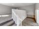 Bright hallway showcasing the transition between carpeted and wood-look floors with white painted walls and railings at 107 Rutledge Rd, Mount Holly, NC 28120