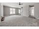 Bright and airy living room with staircase, large windows and neutral colored carpeted floors at 107 Rutledge Rd, Mount Holly, NC 28120