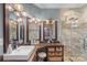 This elegant bathroom features a walk-in shower, an L-shaped vanity, and decorative light fixtures and mirrors at 1135 Ben Black Rd, Midland, NC 28107