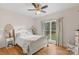 A cozy bedroom featuring hardwood floors, a queen bed with white linens, and a window overlooking a wooded area at 1135 Ben Black Rd, Midland, NC 28107