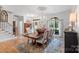 An elegant dining room is displayed with a wood table, seating for six, and a decorative chandelier and rug at 1135 Ben Black Rd, Midland, NC 28107