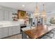 Open kitchen with wooden island, bead-board pendant lights, and custom vent hood at 1135 Ben Black Rd, Midland, NC 28107