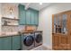 A well-appointed laundry room is displayed with new front load machines, wood countertops, and decorative wallpaper at 1135 Ben Black Rd, Midland, NC 28107