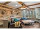 Cozy living room with wood-paneled walls, leather sofa, and large window offering natural light at 1135 Ben Black Rd, Midland, NC 28107