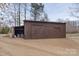 Long wooden outbuilding featuring sliding doors and covered storage at 1135 Ben Black Rd, Midland, NC 28107