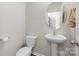 Clean powder room featuring a pedestal sink, toilet, and neutral wall color at 124 Sequoia Forest Dr, Mooresville, NC 28117