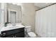 Well-lit bathroom features a sink, toilet, and shower with a white curtain at 130 Monteray Oaks Cir, Fort Mill, SC 29715