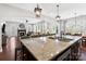 Open kitchen view showcasing granite island with seating and view to adjacent living area and fireplace at 130 Monteray Oaks Cir, Fort Mill, SC 29715