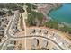 An aerial view displays upscale neighborhood homes by a lake, featuring lush green trees and meandering roads at 1300 Dali Blvd, Mount Holly, NC 28120