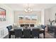 Bright dining room features dark wood table, blue tufted chairs, and large window with backyard views at 1300 Dali Blvd, Mount Holly, NC 28120