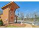 A modern exterior of a brown building near a lake, featuring brown accents and a glimpse of the peaceful surroundings at 1300 Dali Blvd, Mount Holly, NC 28120