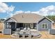 Rear exterior of home with a covered patio, outdoor kitchen, dining area, and fire pit feature at 1300 Dali Blvd, Mount Holly, NC 28120