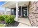 Inviting covered front porch with white columns, dark siding and brick accents at 1300 Dali Blvd, Mount Holly, NC 28120