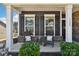 Charming front porch featuring rocking chairs, decorative pillows, and manicured greenery, creating a welcoming entrance at 1300 Dali Blvd, Mount Holly, NC 28120