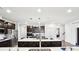 Modern kitchen showcasing a large island with white countertops, dark cabinets, and stainless steel appliances at 1300 Dali Blvd, Mount Holly, NC 28120