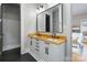 Bathroom with double vanity, wood countertops, framed mirror, and black slate floors at 1418 Seigle Ave, Charlotte, NC 28205