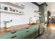 Close-up of the kitchen, showcasing butcher block countertops, green cabinetry, stainless steel appliances, and subway tile backsplash at 1418 Seigle Ave, Charlotte, NC 28205