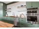 Contemporary kitchen features green cabinetry, butcher block countertops, stainless steel appliances, and white subway tile backsplash at 1418 Seigle Ave, Charlotte, NC 28205