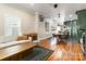 Open-concept living room with a white sectional, wooden coffee table, and hardwood floors extending into the dining area at 1418 Seigle Ave, Charlotte, NC 28205