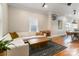 Bright living room featuring a white sectional sofa, wooden coffee table, and hardwood floors at 1418 Seigle Ave, Charlotte, NC 28205