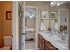 Bathroom featuring double sinks with wood cabinets, tile flooring, and view into bedroom at 15100 Durmast Ct, Mint Hill, NC 28227