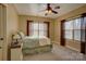 A cozy bedroom offers natural light with two windows, neutral walls, and ceiling fan at 15100 Durmast Ct, Mint Hill, NC 28227