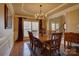 Elegant dining room featuring hardwood floors, a stylish chandelier, and large windows for abundant natural light at 15100 Durmast Ct, Mint Hill, NC 28227