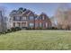 Charming two-story brick home featuring a well-manicured lawn, classic black shutters, and a welcoming front porch at 15100 Durmast Ct, Mint Hill, NC 28227