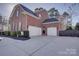 Spacious three-car garage with white doors, providing ample parking and storage at 15100 Durmast Ct, Mint Hill, NC 28227