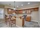 This warm kitchenette features wood cabinets, a kitchen island, granite counters, and a range at 15100 Durmast Ct, Mint Hill, NC 28227