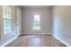 The bedroom has wood-look floors, neutral-colored walls, and a large window with bright white trim at 155 31St Sw St, Hickory, NC 28602