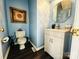 Stylish half bathroom with blue walls, modern vanity, decorative mirror, and elegant fixtures at 1743 Park Grove Nw Pl, Concord, NC 28027