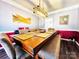 Spacious dining room with a large wooden table, upholstered chairs and bench, and modern lighting fixture at 1743 Park Grove Nw Pl, Concord, NC 28027