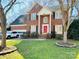 Charming brick home featuring a well-manicured lawn and a bright red front door at 1743 Park Grove Nw Pl, Concord, NC 28027