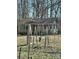 Exterior view of a distressed home with a chain link fence and playground equipment at 185 Flat Stone Dr, Clover, SC 29710