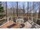 Backyard deck with glass table and chairs, surrounded by tall trees and a white fence at 18948 Kanawha Dr, Cornelius, NC 28031