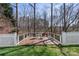 Backyard deck with black chairs and a table, surrounded by grass and a forest at 18948 Kanawha Dr, Cornelius, NC 28031