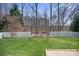 Grassy backyard with a deck and tall trees in the background at 18948 Kanawha Dr, Cornelius, NC 28031