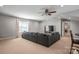 This virtually staged living room features neutral walls, carpeted floors, a large sectional, and a tv, with pot lights at 18948 Kanawha Dr, Cornelius, NC 28031