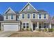 Traditional two-story home with a two-car garage, manicured lawn, and charming front porch at 2025 Sweet Magnolia Ln, Clover, SC 29710