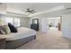 Large main bedroom with a tray ceiling, ceiling fan, and a doorway to another room providing seamless transitions at 2025 Sweet Magnolia Ln, Clover, SC 29710